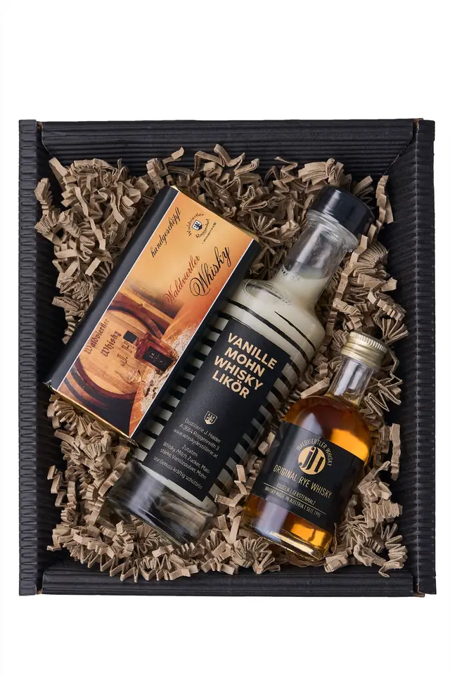 Geschenkbox einer Destillerie mit Whiskylikör, kleiner Whiskyflasche und Schokolade in Holzwolle