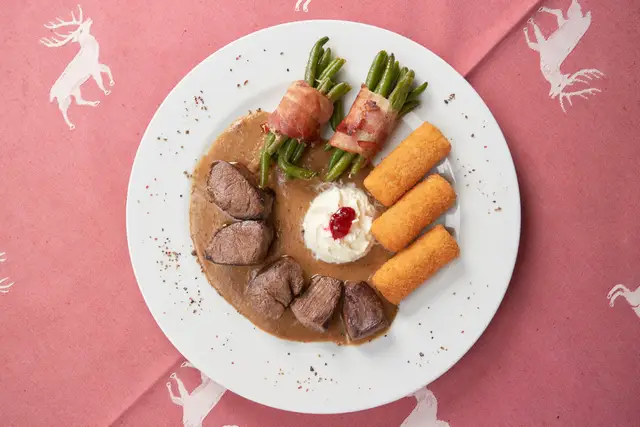 Zarte Wildmedaillons mit Speckfisolen, Kroketten und Preiselbeeren, Foodfotografie für die Wildsaison
